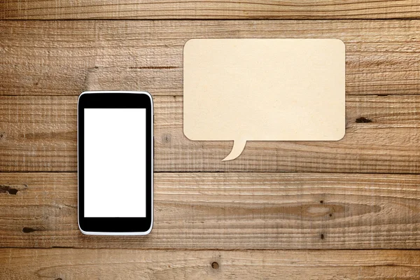 Smartphone and speech bubble on wooden background