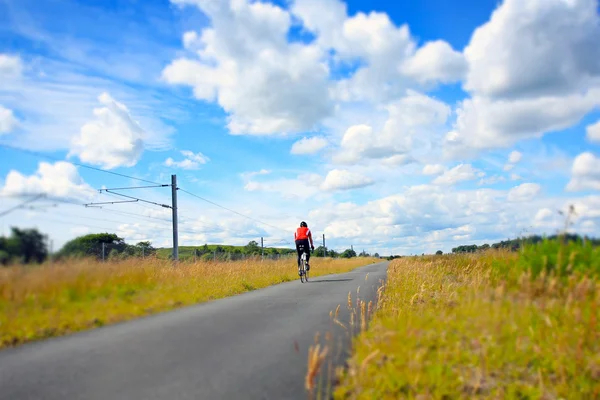 A cyclist on an empty rural road