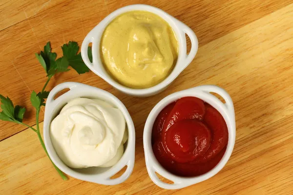 Three kinds of sauces, mustard, ketchup and mayo