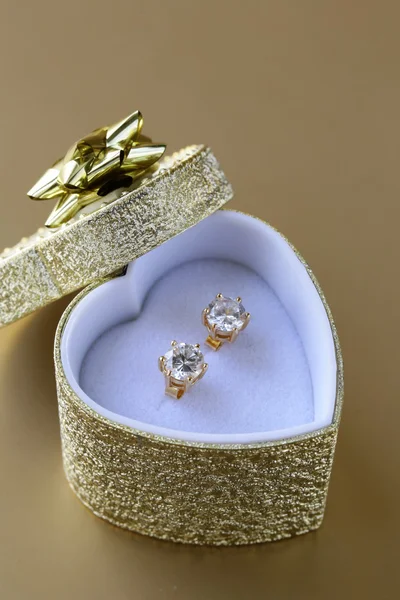 Gold earrings stud with diamonds in a gold box