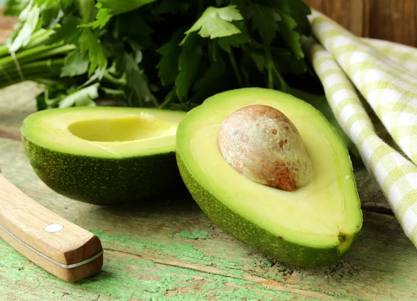 Ripe avocado cut in half on a wooden table