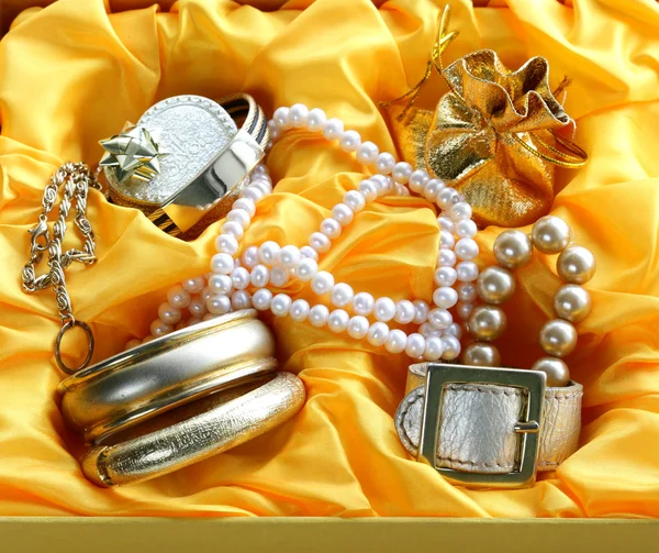 Gold jewelry and pearls in a yellow gift box