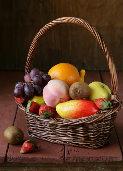 Still life wicker basket with fruit on a wooden table