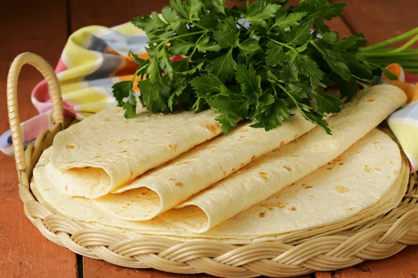 Stack of homemade whole wheat flour tortillas on a wooden table