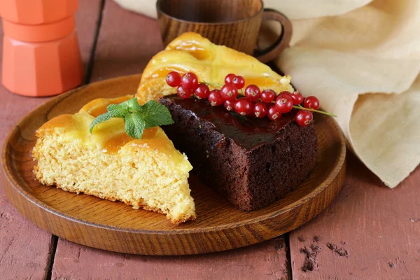 Assorted cake - chocolate and fruit on wooden plate