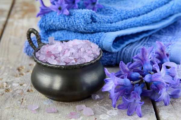 Spa still life .Bath lilac salt, towel and flowers
