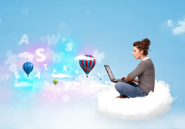 Young woman sitting in cloud with laptop