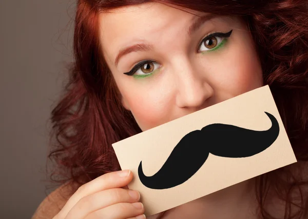 happy cute girl holding paper with mustache drawing