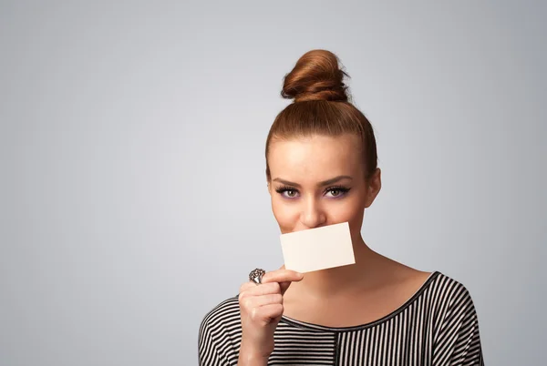 Cute girl holding white card at front of her lips with copy spac — Stock Photo #33851615