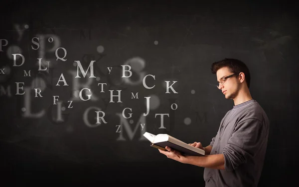 Young man reading a book with alphabet letters