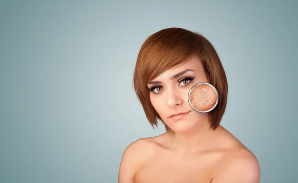 Beautiful young girl with magnifying glass of skin damage