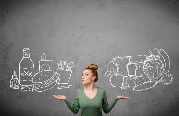 Woman standing between healthy and unhealthy foods