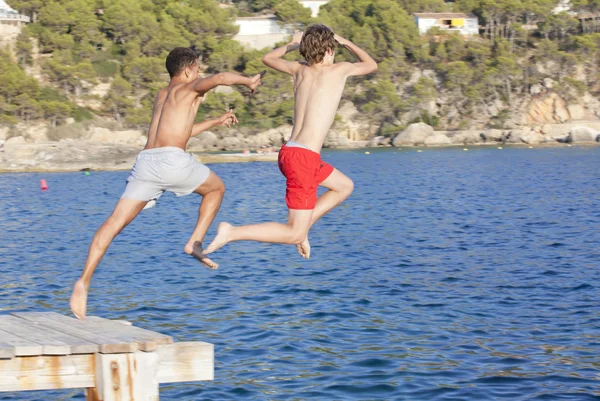 Summer camp kids jumping in sea