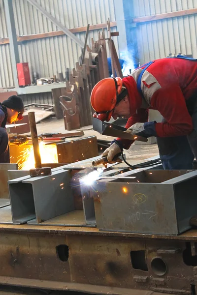 Welders work in the factory floor