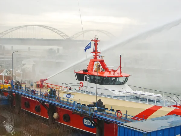 Ship melts the ice by steam gun in the harbor of Gorinchem