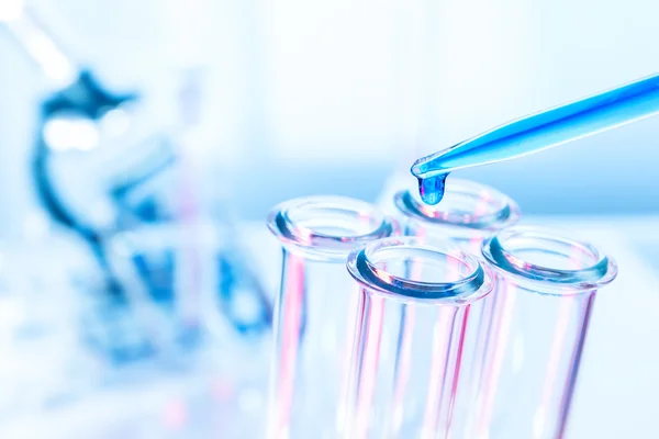 Pipette and test tube on blue background