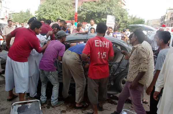 Rescue officials busy in rescue work at the site of a bomb blast targeting the convoy of Sindh High Court Justice Baqar Maqbool, at Burns Road in Karachi