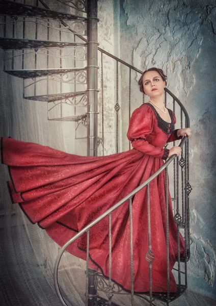 Beautiful woman in medieval dress on the stairway