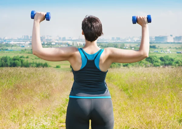 Plus size woman exercising with dumbbells