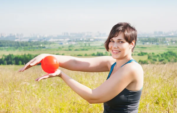 Beautiful plus size woman exercising with ball