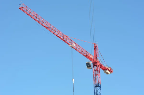Large red and blue crane with blue sky