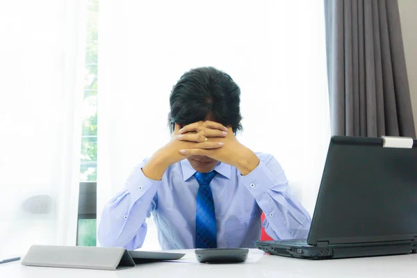 Serious business man sitting with job on desk