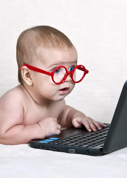 Funny kid in the glasses with a netbook
