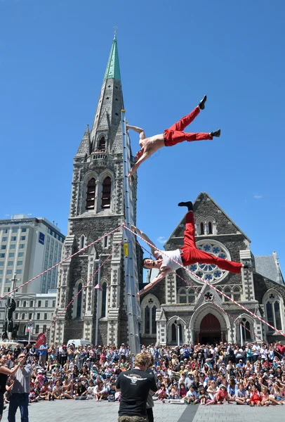Acrobats (The Flash) perform on a ladder in front of the Cathedr