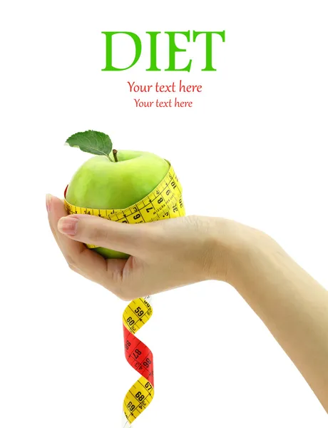 Diet concept. Female hand holding fresh apple with measuring tape