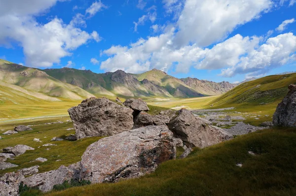 Big stones and picturesque hills under blue sky with clouds