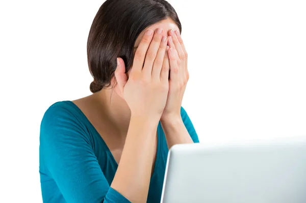 Young tired woman face palm working on laptop