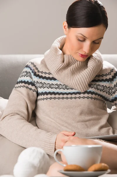 Smiling young woman using tablet computer at home at night befor