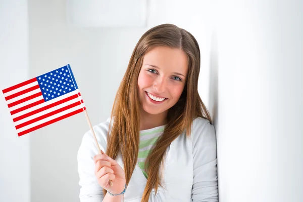Portrait of a lovely young woman with United State's flag smiling