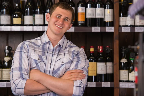 Portrait of confident male with a selection of wines in the back