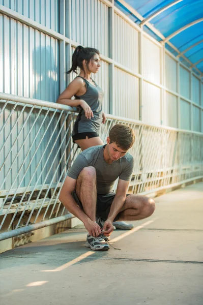 Man and woman tying shoelaces