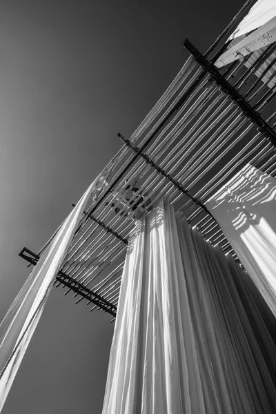 Indian man hanging cotton clothes to dry under the sun