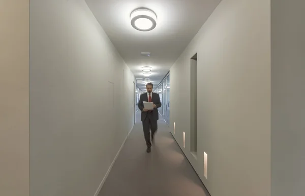 Business man walking in an office corridor