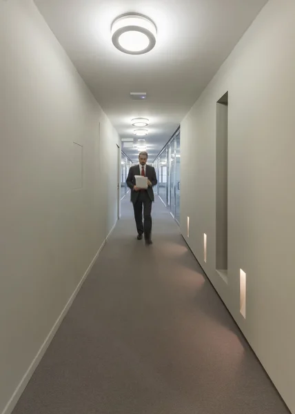 Business man walking in an office corridor