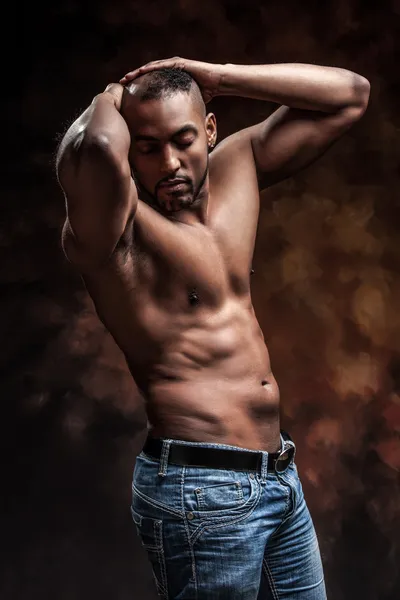 Naked man with perfect body posing in jeans