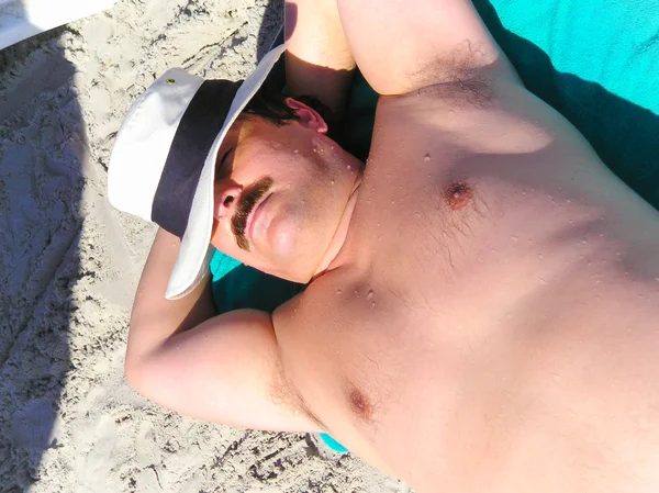 Man sunbathing at a beach