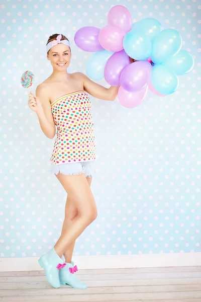 Retro woman with lollipop and balloons