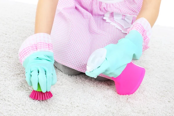 Woman cleaning stains on a carpet