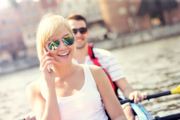 Young woman talking on the phone in a canoe