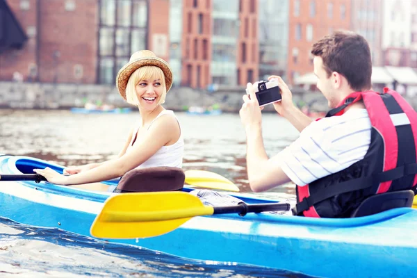 Happy tourists taking pictures in a canoe