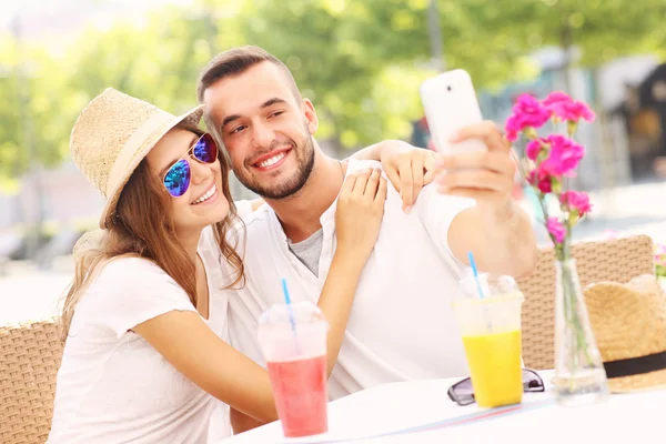 Happy couple taking selfie in a cafe