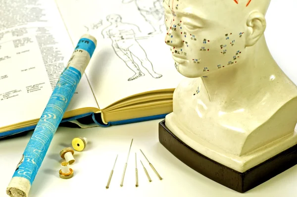 Acupuncture needles, head model, textbook and moxa roll