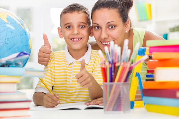Smiling mother helping son to do his homework
