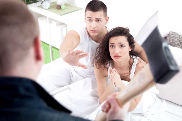 Caught in cheating, angry husband holding the hatchet, a woman a