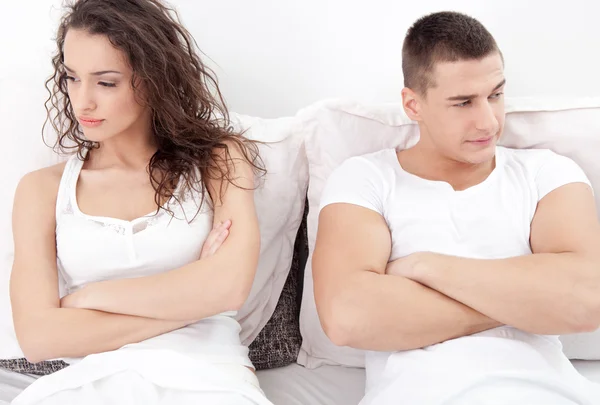 Unhappy young  couple in bedroom under stress