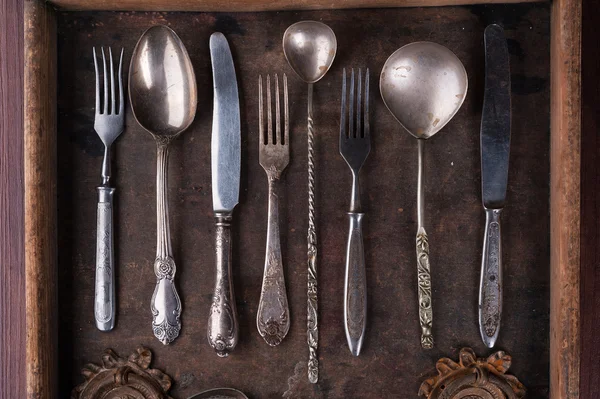 Old cutlery in an old wooden box